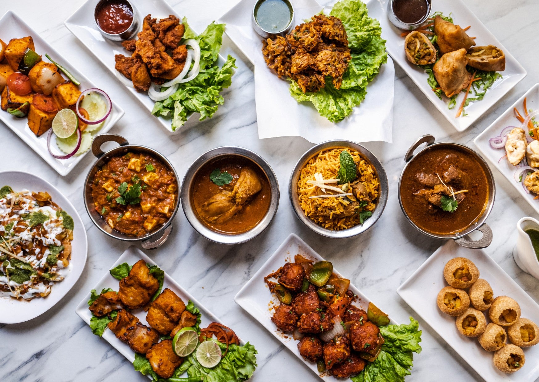 An assortment or soups, stews and food laid out on a table